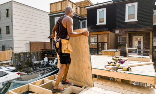 A contractor installing a piece of osb to a deck being built